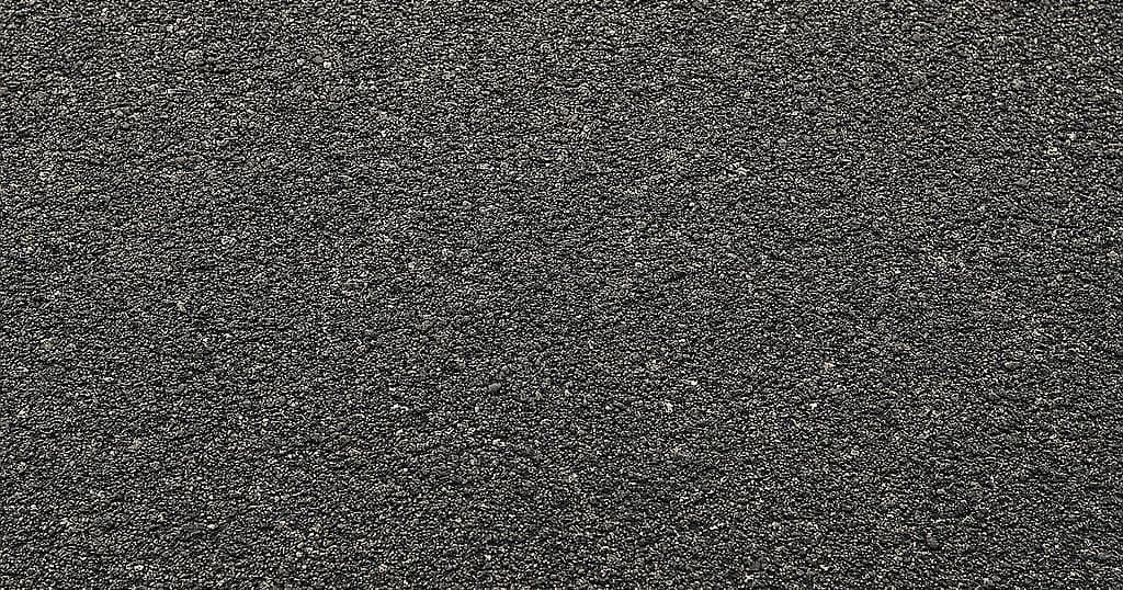 Close-up of an asphalt driveway surface showing its granular texture